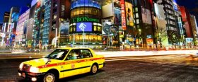 A Tokyo taxi driving through the neon-lit streets of Shinjuku,